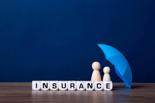 word insurance written on white plastic cubes under a blue mini umbrella